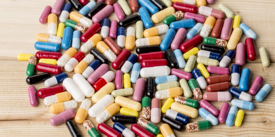 tas de médicaments colorés et pilules sur fond en bois