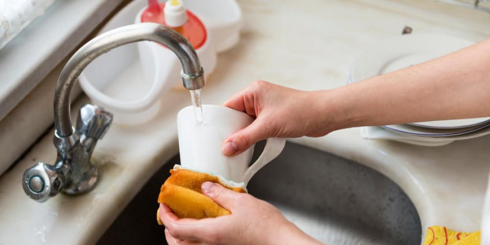 les mains des femmes laver la vaisselle