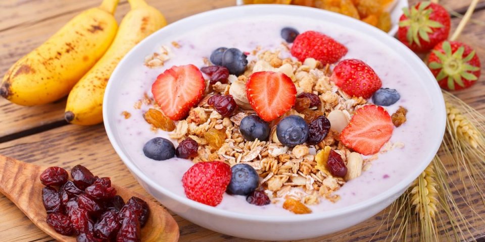 healthy breakfast with fresh fruits, yogurt and granola on rustic wooden table