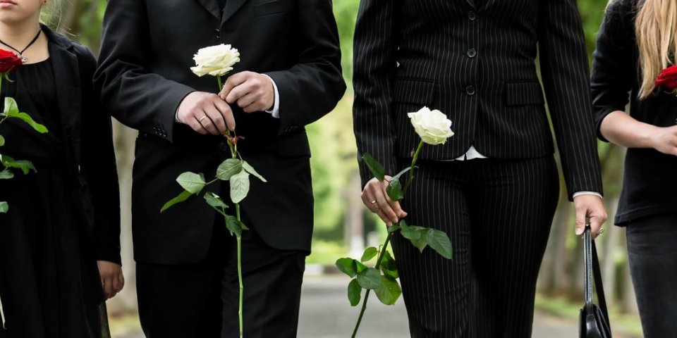 torse de famille sur deuil de cimetière tenant des roses rouges et blanches dans les mains