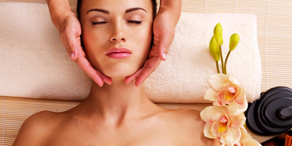 masseur faire masser la tête d'une femme adulte dans le salon spa