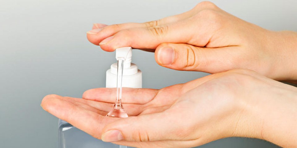 mains féminines utilisant un distributeur de pompe à gel désinfectant pour les mains