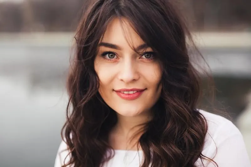 belle femme visage agrandi bouchent portrait de jeune femme avec maquillage naturel souriant et regardant à l'extérieur de la caméra
