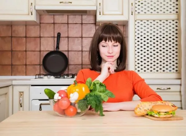 régime amaigrissant concept alimentation saine belle jeune femme en choisissant entre les légumes et la perte de poids fast-food