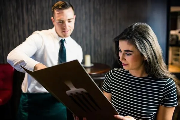femme séduisante commande au serveur du menu