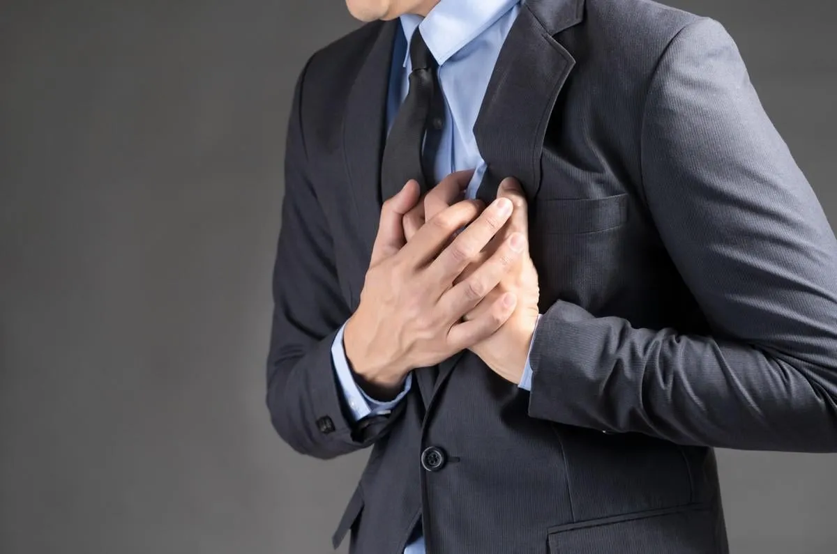 businessman holding his heart in pain