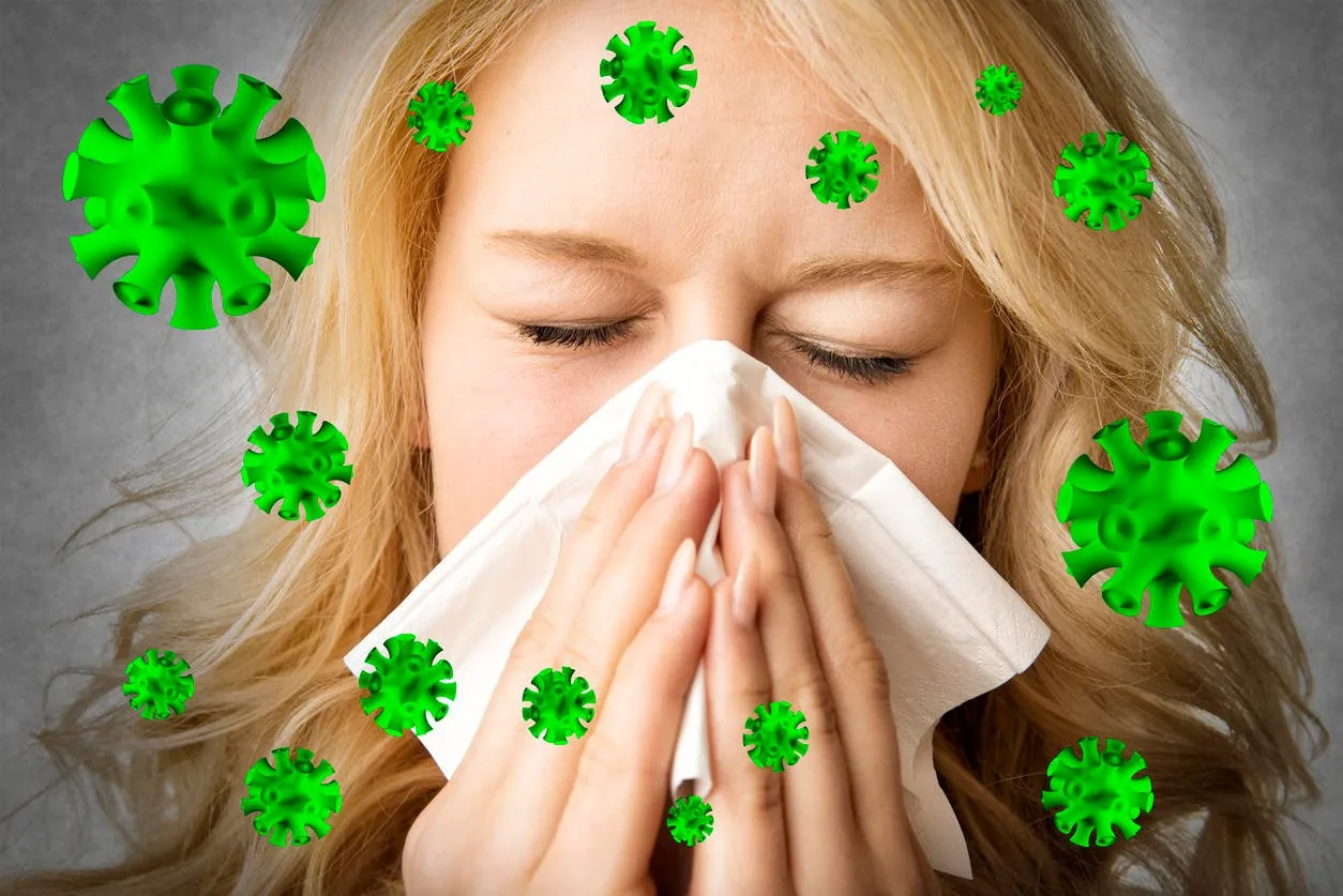 portrait of a ill blond woman who is sneezing virus in a tissue