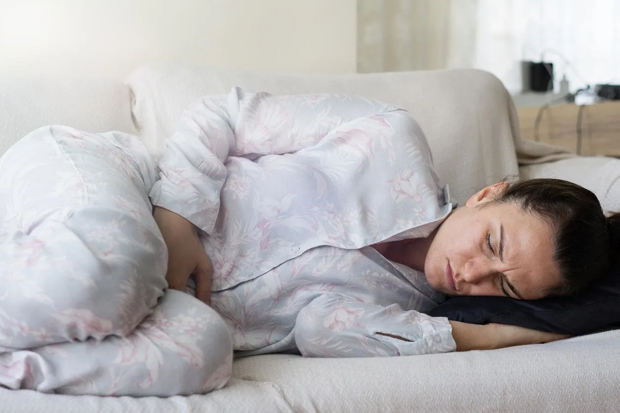 young adult woman holding her crotch