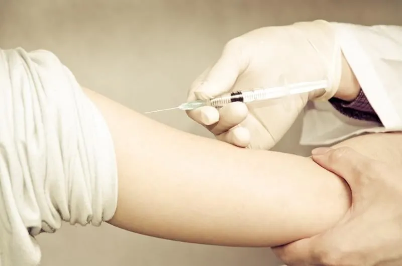 médecin injectant la vaccination avec la main du patient