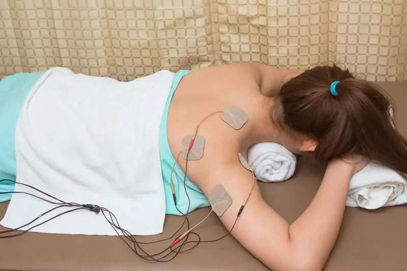 femme avec stimulateur électrique pour augmenter la force musculaire et libérer la douleur, le traitement et la rééducation