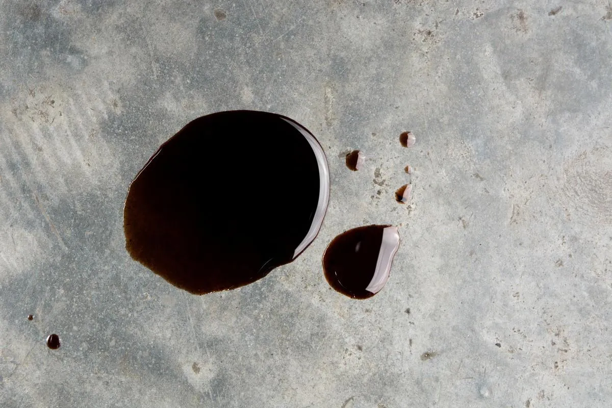 old black oil motor car leak or drip on concrete floor on top view