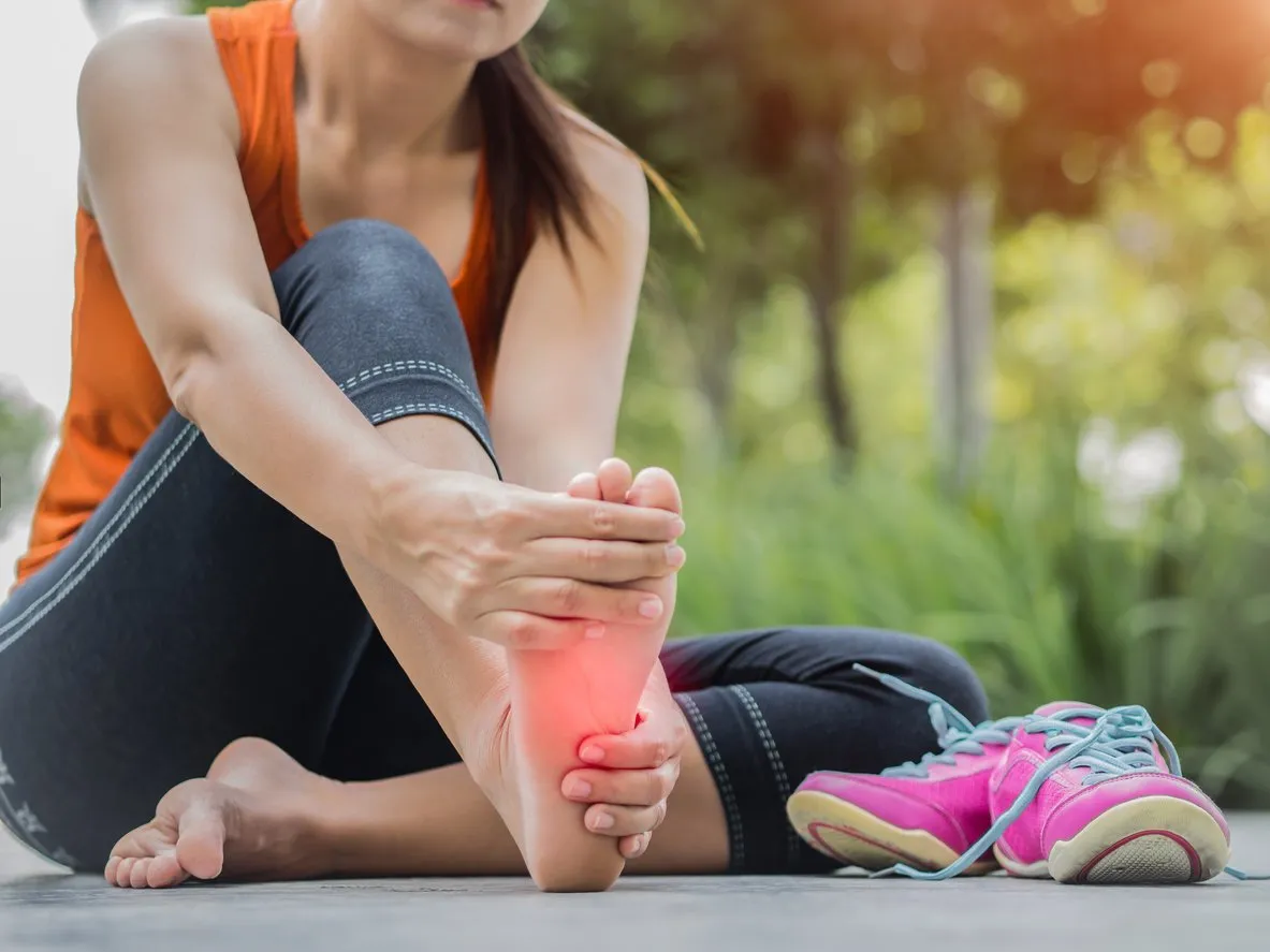 soft focus woman massaging her painful foot while exercising  running sport injury concept