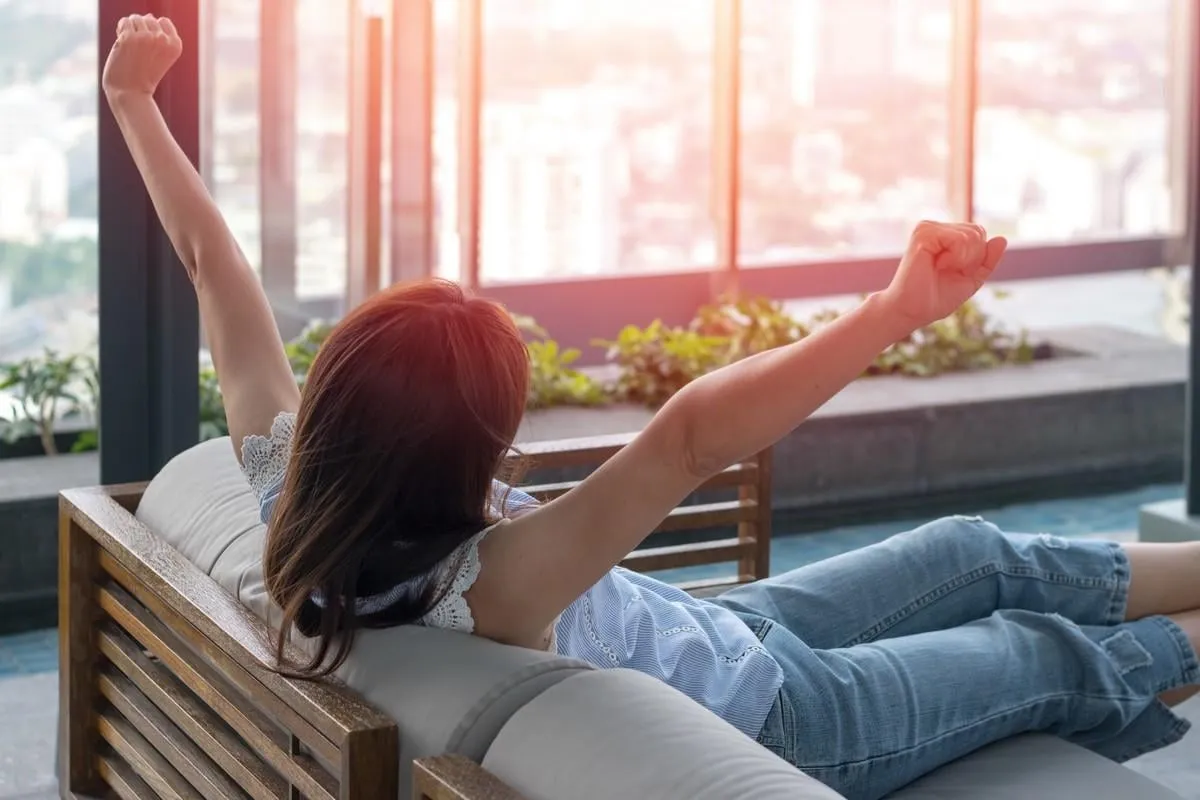 easy relax business woman lifestyle after work at hotel sitting hands behind head for happy businesswomen people simplify your life week international happiness day