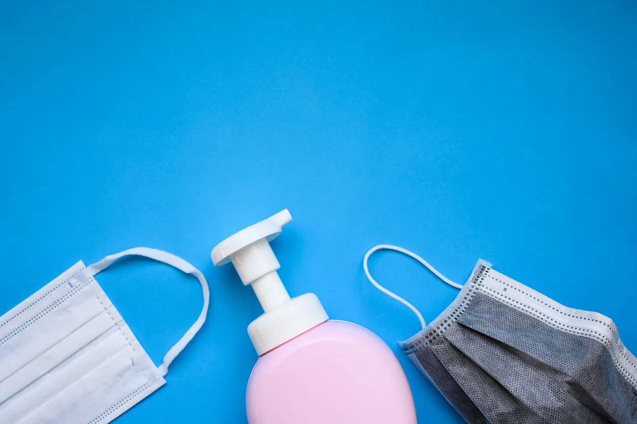 protective face mask and hand cleansing soap and alcohol gel on blue background concept for prevent and protect coronavirus covid-19