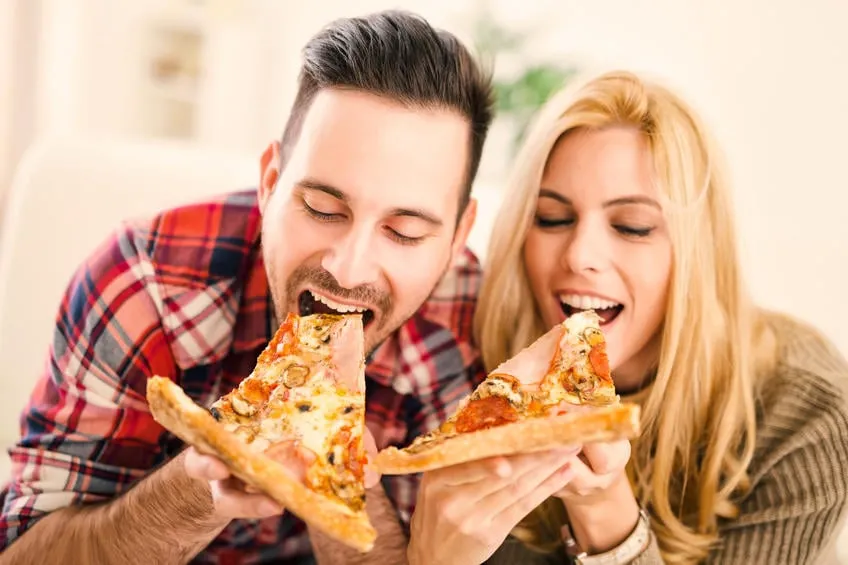 portrait d'un couple heureux ils rient et mangent des pizzas et passer un bon moment