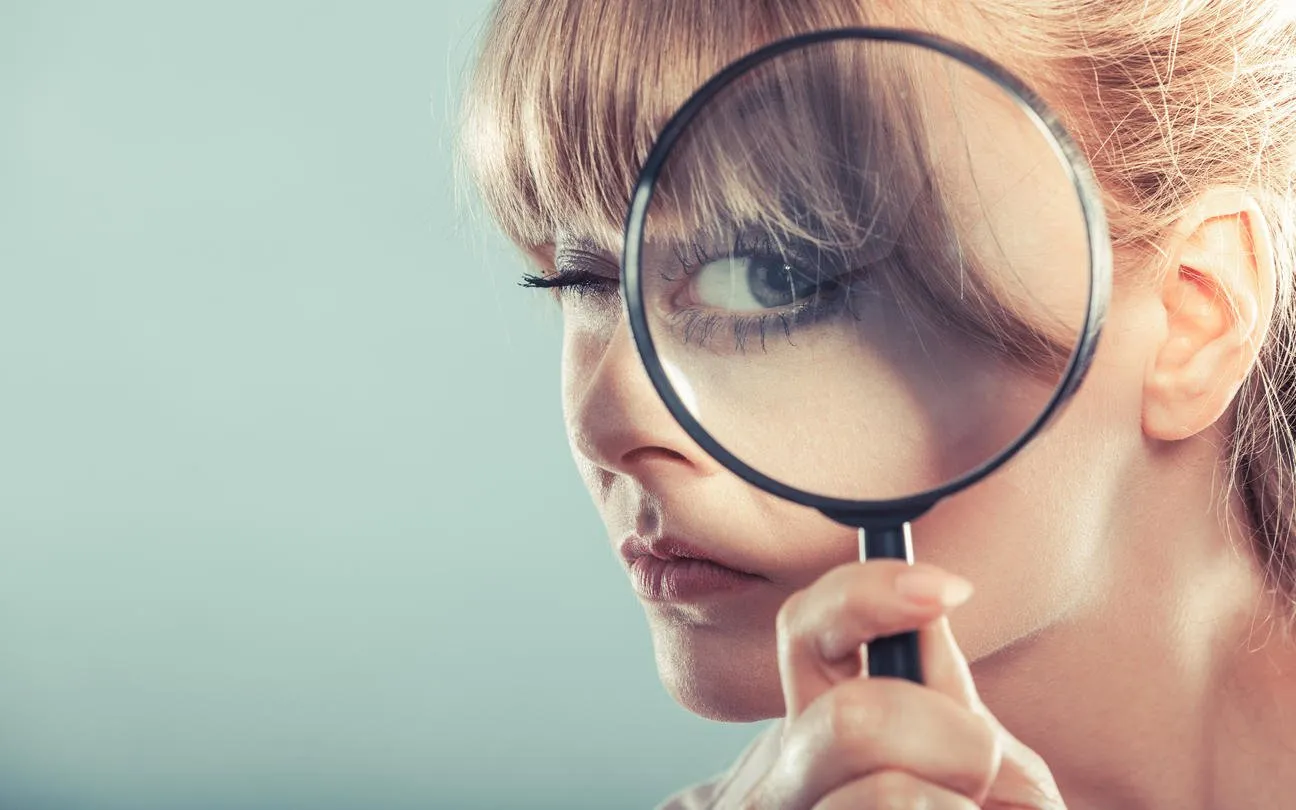 investigation exploration education concept closeup funny woman face, girl holding on eye magnifying glass loupe