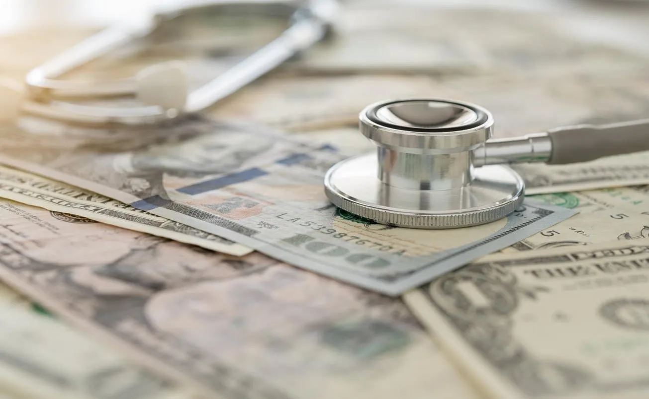 medical cost, stethoscope on dollar banknote money concept of health care costs, finance, health insurance fund