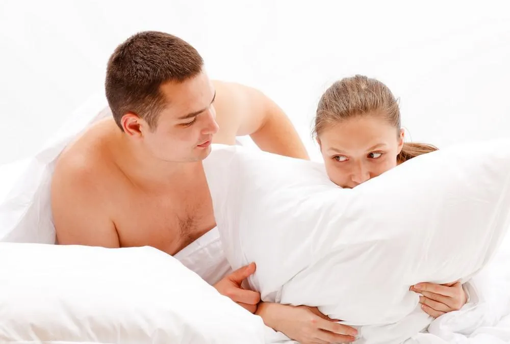 jeune couple nu au lit, homme réconfortant femme