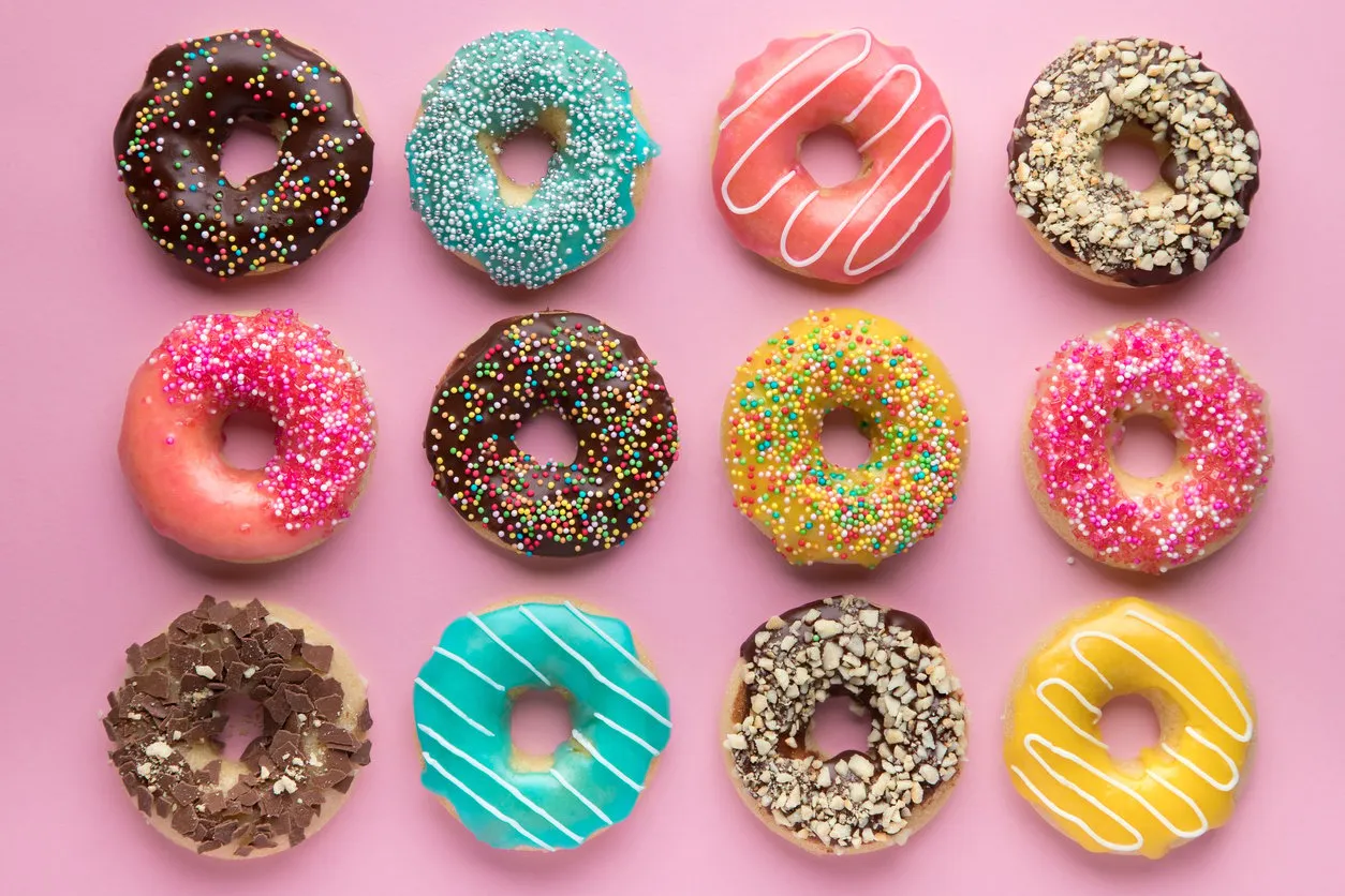 colorful sweet background delicious glazed donuts on pink background