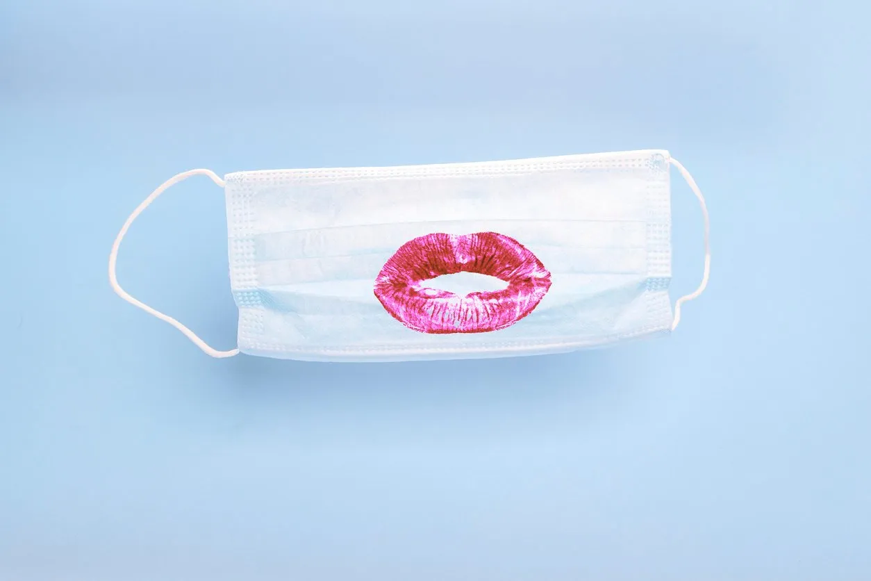 medical mask with print of female lipstick kiss lips on blue background prevention and protection of the population during an epidemic, corona virus (covid19), colds and viral flu