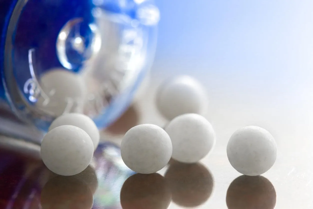 extreme macro of homeopathic medications - small white balls and the container