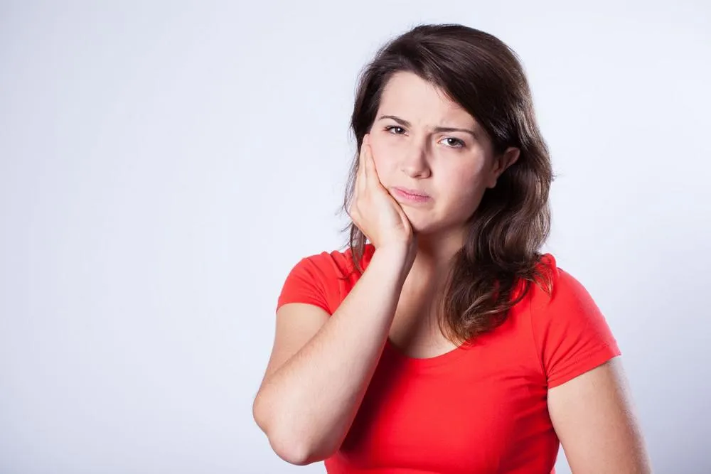 jeune jolie fille avec une douleur horrible dans la dent