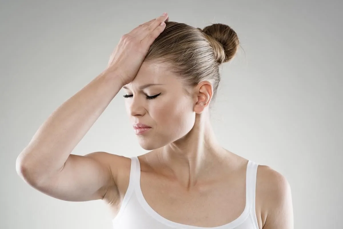 memory loss close-up of woman touching her forehead in pain