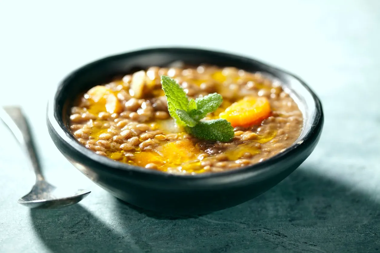 closeup of lentil soup, the lentils have cooked for 3 hours in order to form its own thick sauce, it also has carrots and onions