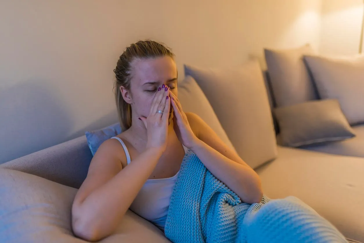 young woman with headache,sniffle and sinus pain sinus ache causing very paintful headache unhealthy woman in pain young woman with sinus pressure pain