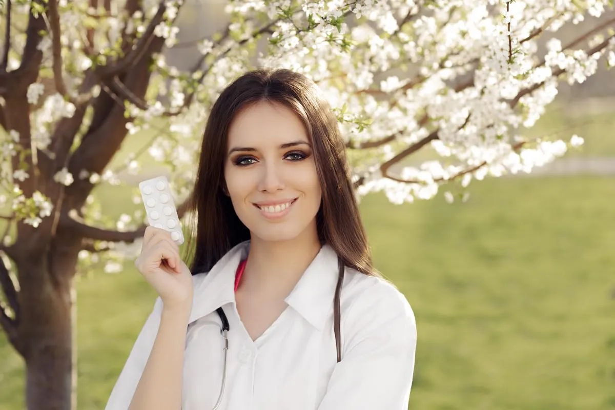 femme médecin souriant et tenant des pilules