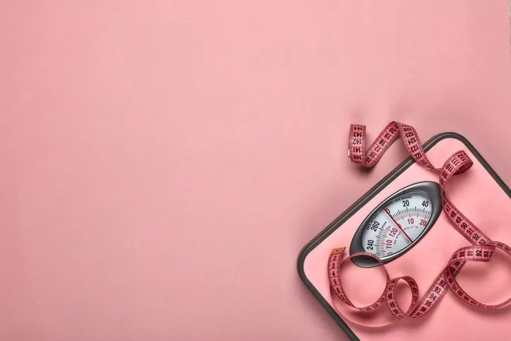 female fitness still life scales and measuring tape on pink background mockup planning of diet and trainings top view with copy space healthy lifestyle concept slimming