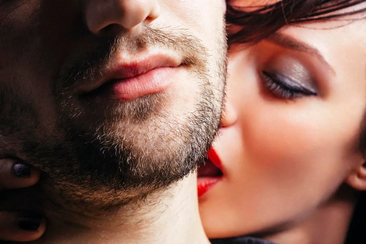 gros plan d'une femme embrassant passionnément un homme sur le cou