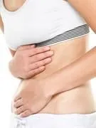 femme de douleur à l'estomac ayant des douleurs abdominales, des maux d'estomac ou des crampes menstruelles gros plan de jeune modèle féminin isolé sur fond blanc