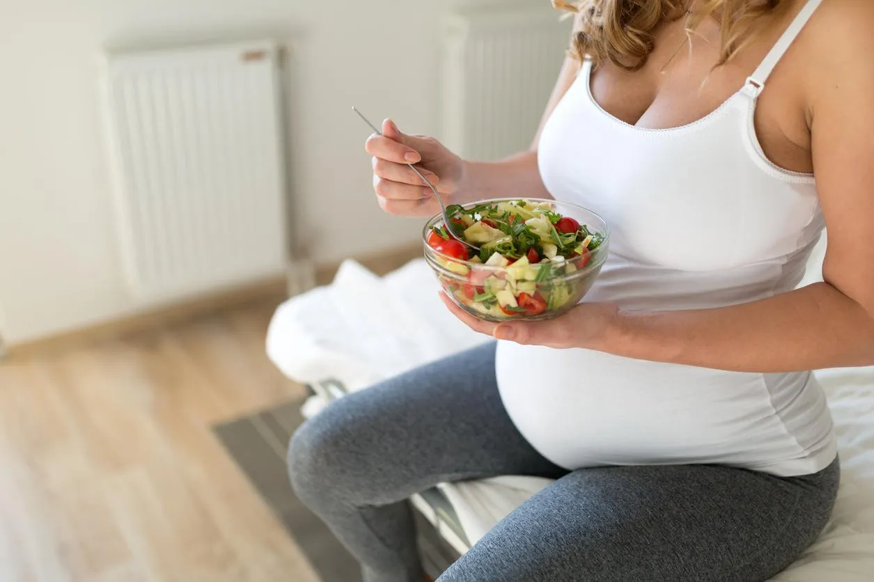 pregnant woman eating fresh healthy salad