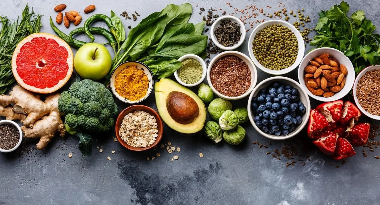 healthy food clean eating selection  fruit, vegetable, seeds, superfood, cereals, leaf vegetable on gray concrete background copy space