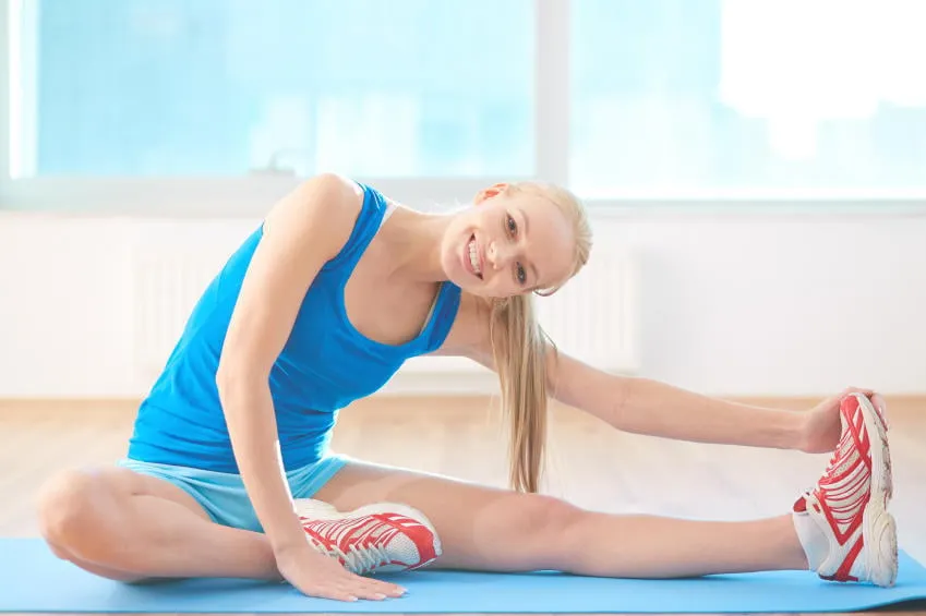 femme fit regarder la caméra pendant l'exercice dans la salle de gym