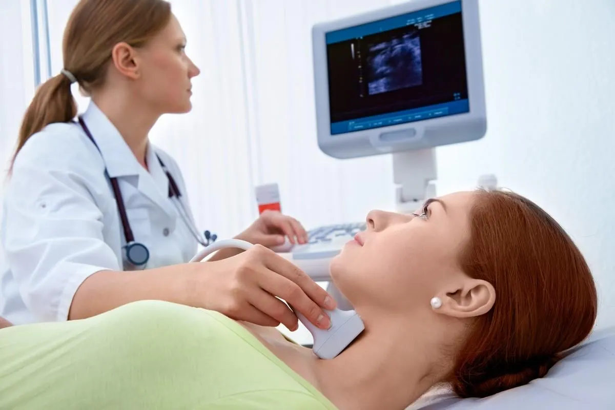 woman getting ultrasound of a thyroid from doctor