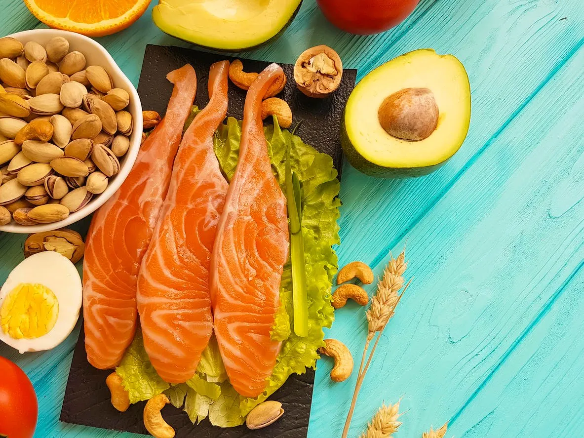 red fish, avocado, nuts on a blue wooden background, healthy food