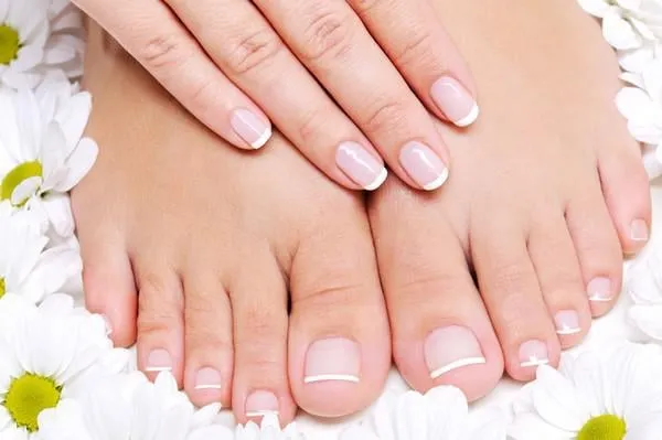 traitement de beauté d'un pied féminin avec la fleur de camomille autour d'elle