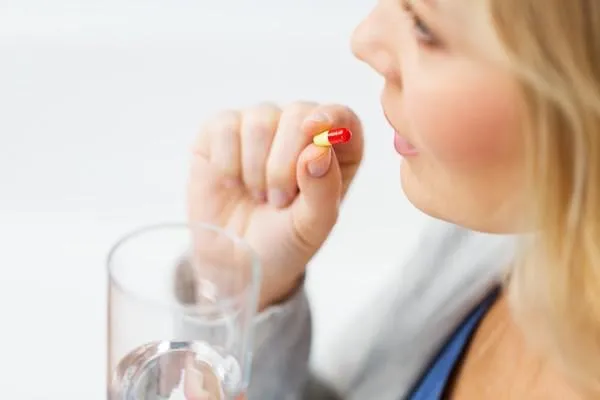 concept de médecine, de soins de santé et de personnes - gros plan de femme prenant en pilule