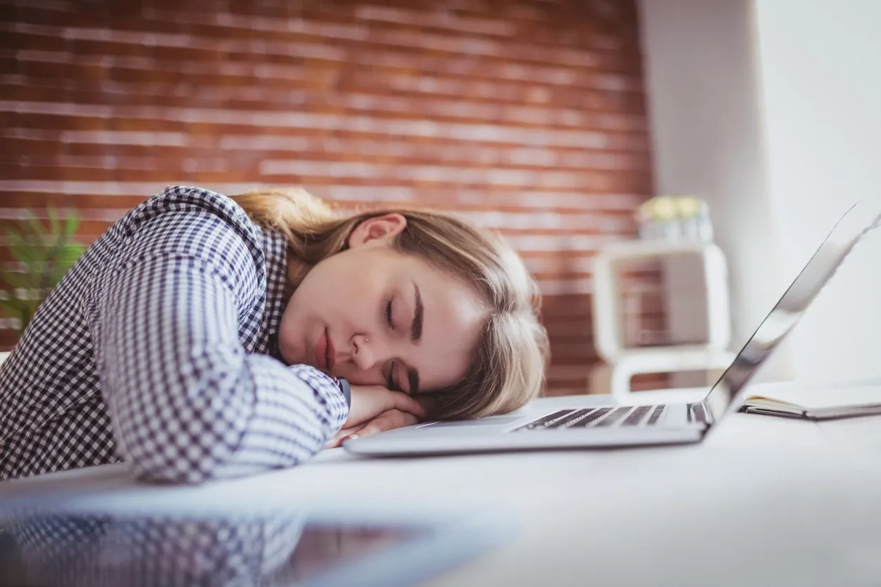 tired hipster businesswoman sleeping on her desk on office