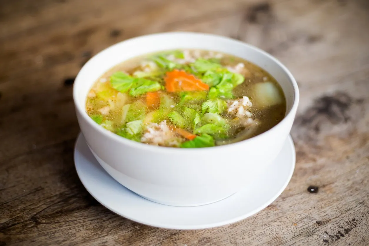 fresh prepared asian aromatic broth soup with cabbage, carrot and pork traditional thai cuisine made of fresh ingredients