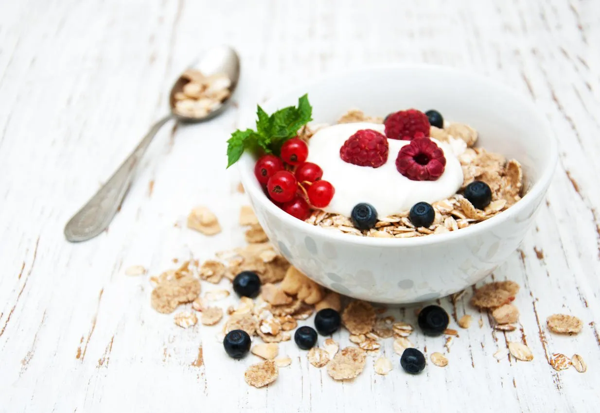 breakfast with fresh berries on a old wooden table