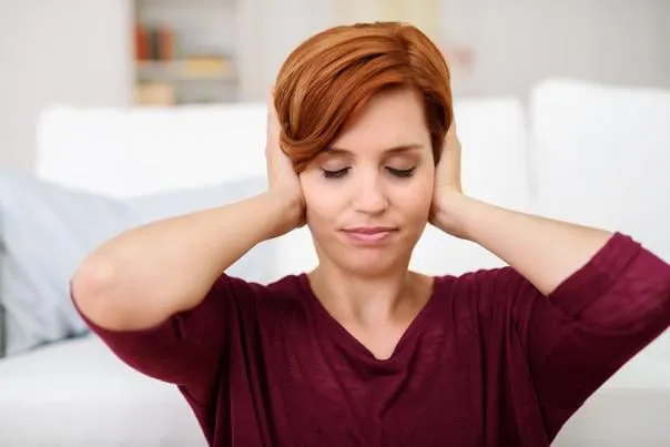 jeune femme couvre ses oreilles