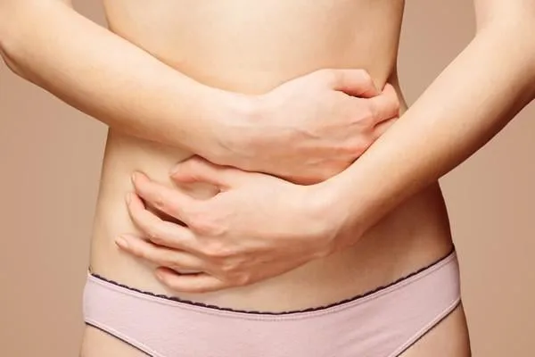 femme méconnaissable tient son abdomen, vue de face, douleur abdominale ou menstruelle