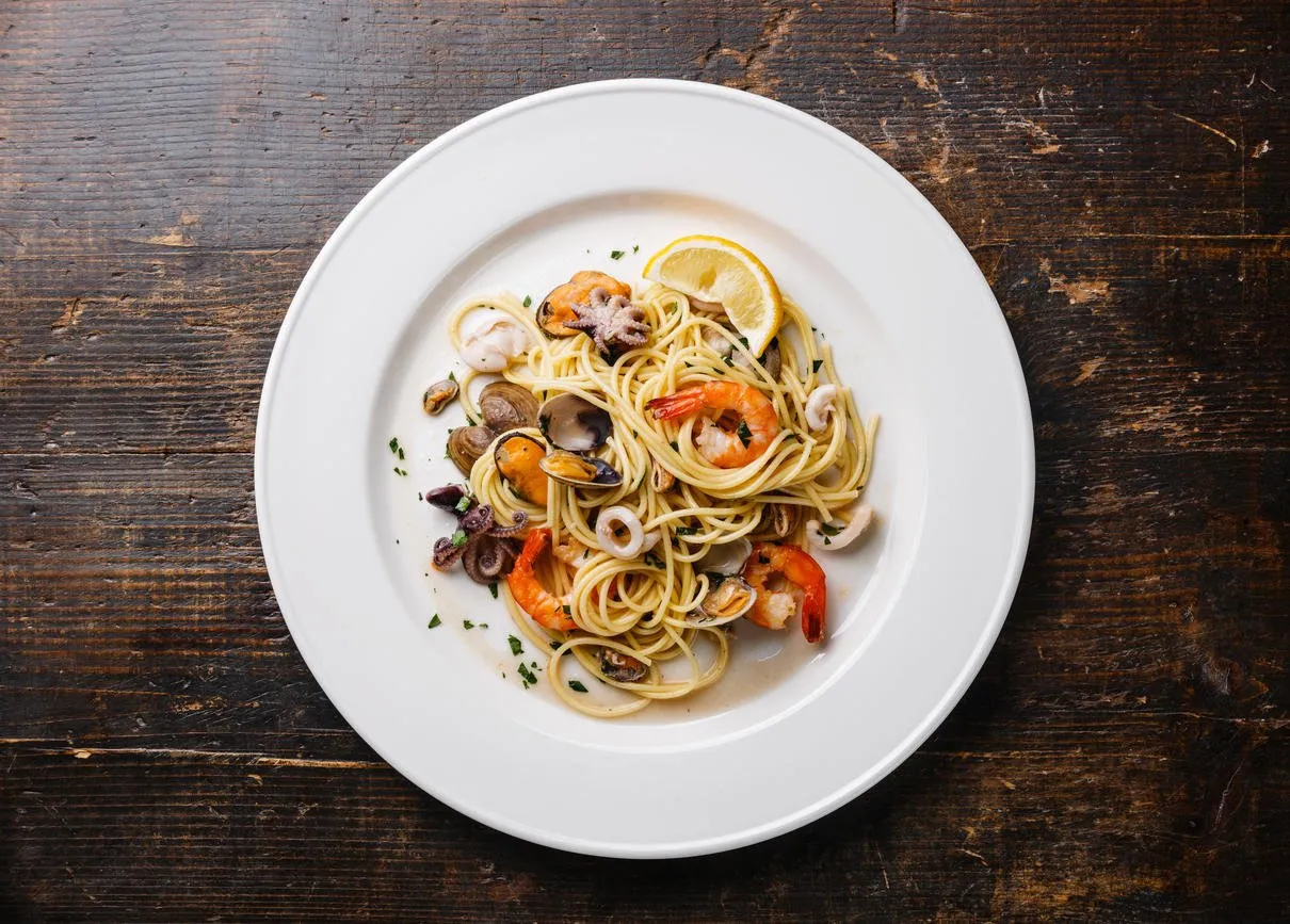 spaghetti de pâtes de fruits de mer aux palourdes, crevettes, cocktail de fruits de mer sur plaque blanche