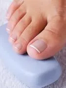 beau pied femelle unique avec la belle pédicure sur les orteils sur une tranche de savon bleu