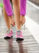chaussures de course pieds nus chaussures de course closeup femme attacher lacets avant de faire du jogging dans les chaussures de course pieds nus minimalistes sur brooklyn bridge, new york, usa