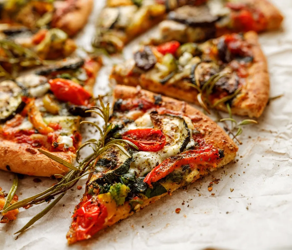 vegetarian pizza with addition grilled vegetables and aromatic herbs, divided into portions