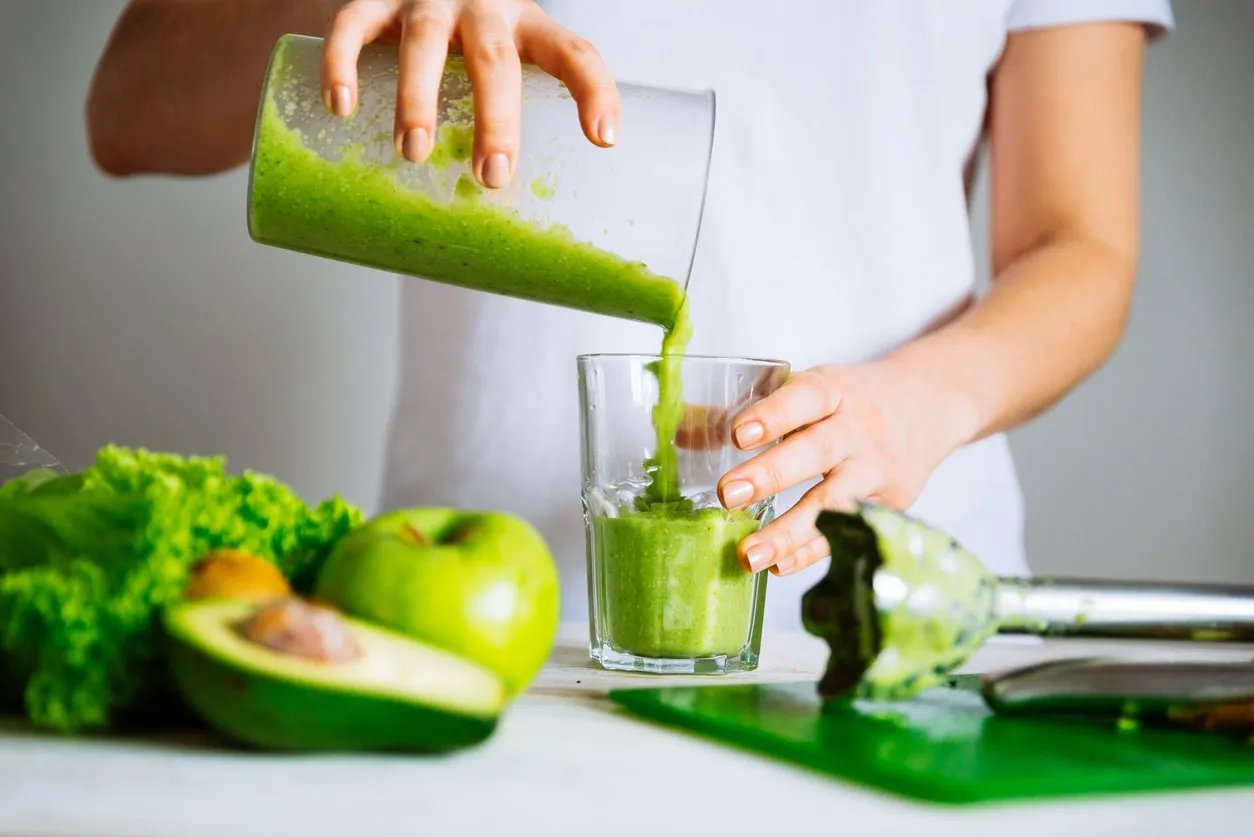 woman transfuse smoothie to glass healthy food concept